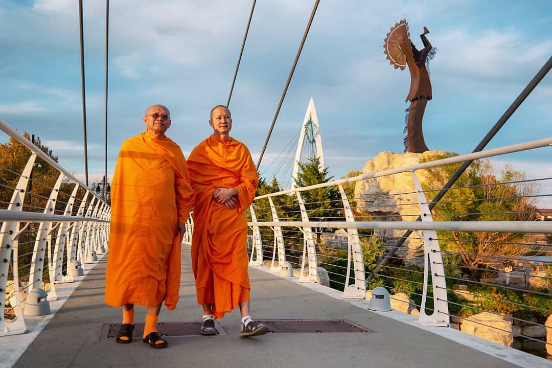  A pair of Buddhist monks cross the bridges at Keeper of the Plains, Wichita, Kansas. 