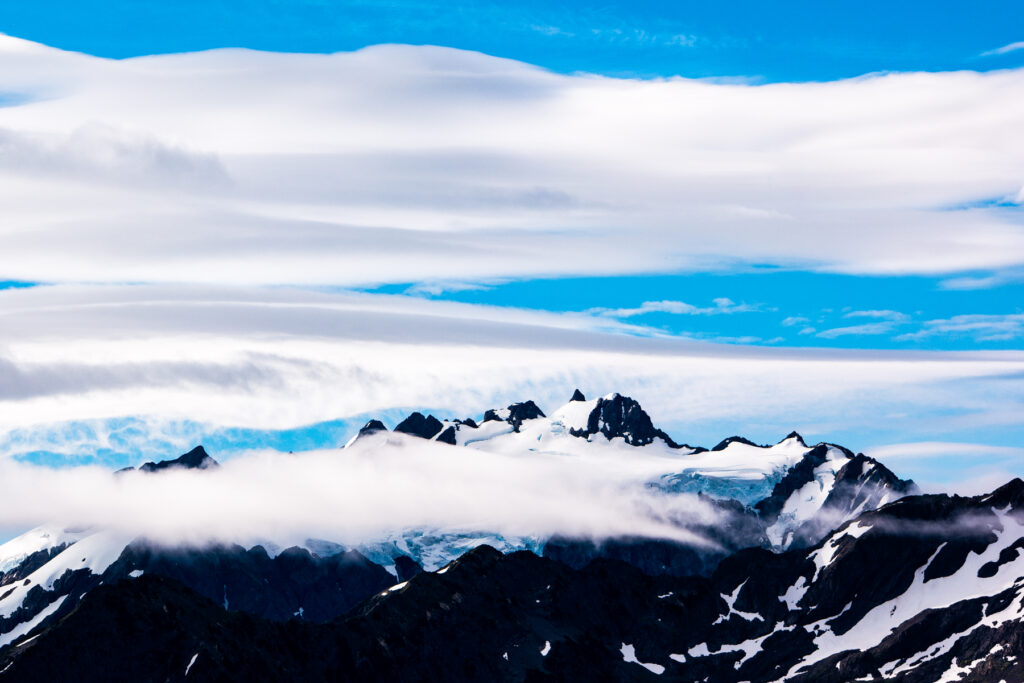 Cloud layer breaking over the snow-covered peaks of Mount Olympus, Olympic National Park, Washington